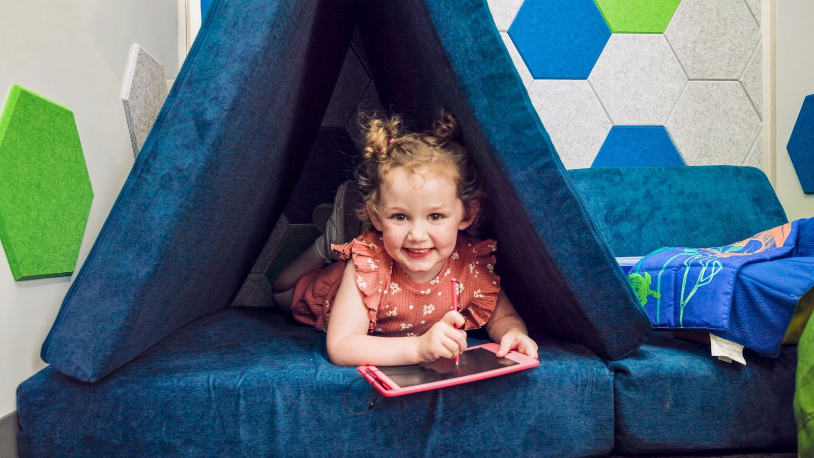 Toddler drawing on ipad while smiling at camera